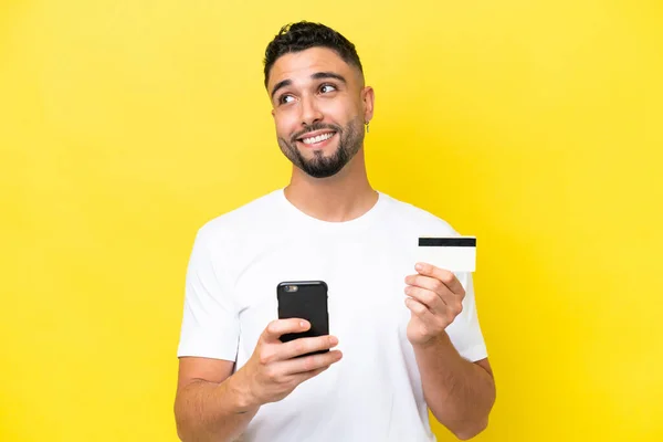 Young Arab Handsome Man Isolated Yellow Background Buying Mobile Credit — Φωτογραφία Αρχείου