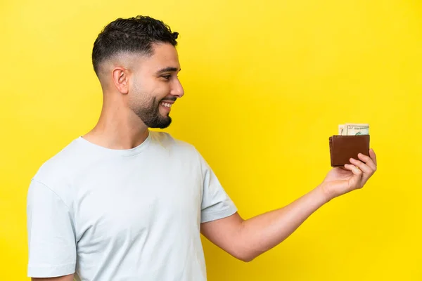 Jonge Arabische Man Met Een Portemonnee Geïsoleerd Gele Achtergrond Met — Stockfoto