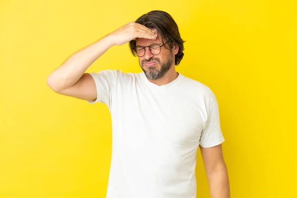 頭痛を持つ黄色の背景に隔離されたシニアオランダ人男性 — ストック写真
