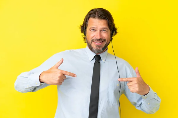 黄色の背景に独立したヘッドセットを使用して作業テレマーケティングオランダ人男性誇りと自己満足 — ストック写真
