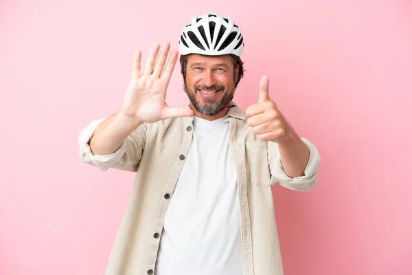 Senior Holländer Mit Fahrradhelm Isoliert Auf Rosa Hintergrund Zählen Sechs — Stockfoto