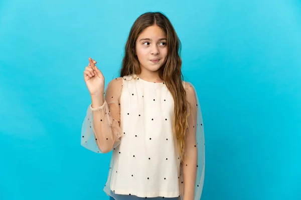 Menina Sobre Fundo Azul Isolado Com Dedos Cruzando Desejando Melhor — Fotografia de Stock
