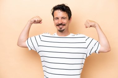 Beyazların arka planında izole edilmiş genç beyaz adam güçlü bir jest yapıyor.