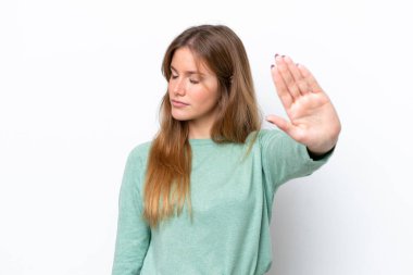 Beyaz arka planda izole edilmiş genç beyaz kadın dur hareketi yapıyor ve hayal kırıklığına uğruyor.