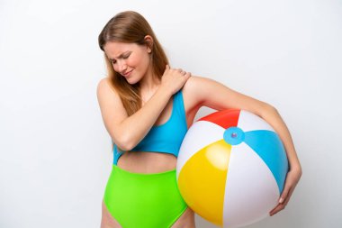 Tatillerde plaj topu tutan genç bir kadın beyaz arka planda izole edilmiş bir şekilde çabaladığı için omuz ağrısından muzdarip.