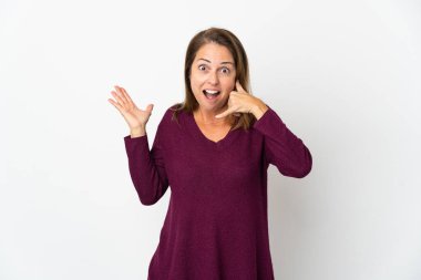 Beyaz arka planda izole edilmiş orta yaşlı Brezilyalı bir kadın telefon jesti yapıyor ve şüpheli.