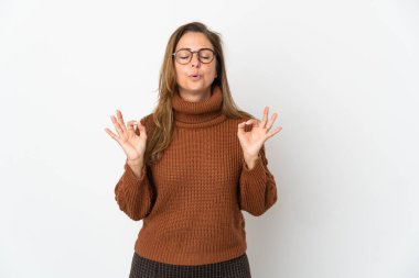 Orta yaşlı Brezilyalı kadın Zen pozunda beyaz arka planda izole edilmiş.