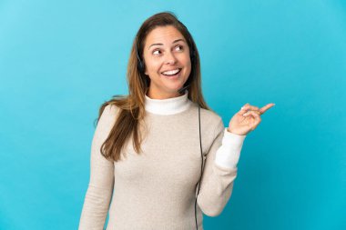 Genç pazarlamacı kadın, izole edilmiş mavi arka planda parmağını kaldırarak çözümü bulmaya çalışıyor.