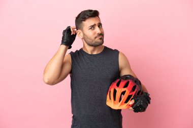 Pembe arka planda izole edilmiş genç bisikletçinin şüpheleri var.