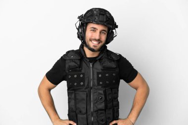 Beyaz arka planda izole genç beyaz SWAT kolları kalçasında poz ve gülümseme