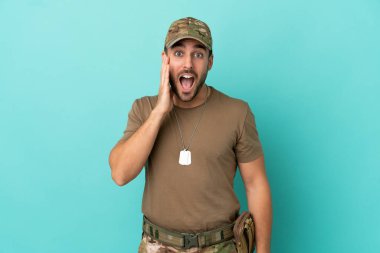 Mavi arka planda izole edilmiş, şaşırmış ve şok olmuş bir yüz ifadesi olan asker.