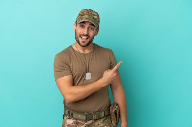 Mavi arka planda izole edilmiş künyesi olan ordu bir ürünü sunmak için kenarı işaret ediyor.