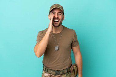 Mavi arka planda izole edilmiş, ağzı açık bağıran bir ordu mensubu.