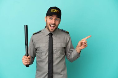 Mavi arka planda izole edilmiş genç bir güvenlik görevlisi var.