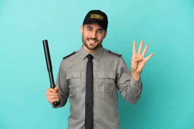 Mavi arka planda izole edilmiş genç güvenlik görevlisi mutlu ve parmaklarıyla dört kişi sayıyor.