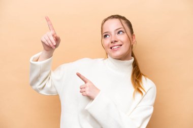 Beyazların arka planında izole edilmiş genç beyaz kadın işaret parmağıyla işaret etmek harika bir fikir.