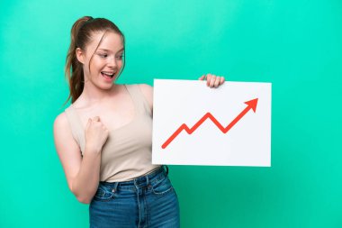 Yeşil arka planda izole edilmiş genç beyaz kadın elinde büyüyen bir istatistik okuyla bir işaret tutuyor ve zaferi kutluyor.