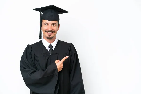 Jonge Afgestudeerde Man Geïsoleerd Witte Achtergrond Wijzend Naar Zijkant Een — Stockfoto