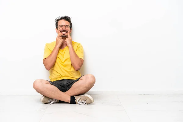 Joven Hombre Caucásico Sentado Suelo Aislado Sobre Fondo Blanco Sonriendo — Foto de Stock