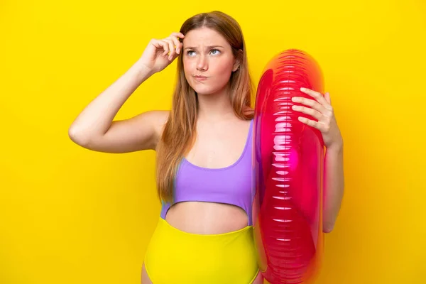 Jonge Blanke Vrouw Met Luchtbed Geïsoleerd Gele Achtergrond Met Twijfels — Stockfoto