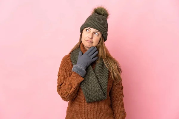 Medelålders Kvinna Med Vinter Hatt Isolerad Rosa Bakgrund Tittar Upp — Stockfoto