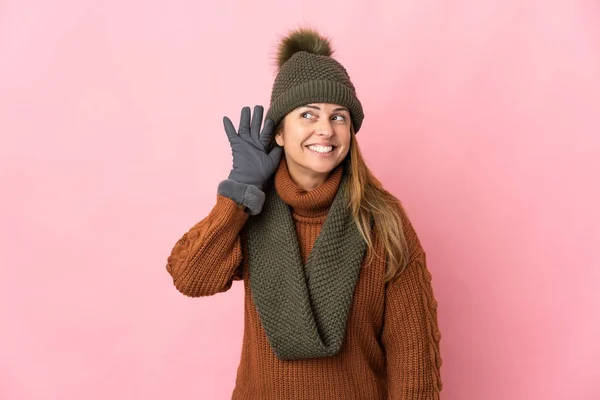 Donna Mezza Età Con Cappello Invernale Isolato Sfondo Rosa Ascoltando — Foto Stock