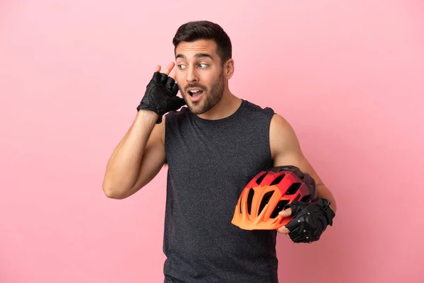 Young Cyclist Man Isolated Pink Background Listening Something Putting Hand — Stock Fotó