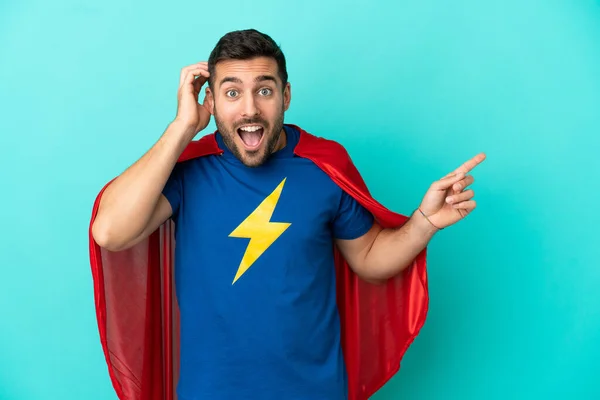 Super Hero Caucasian Man Isolated Blue Background Surprised Pointing Finger — Zdjęcie stockowe