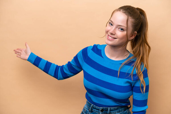 Young caucasian woman isolated on beige background extending hands to the side for inviting to come