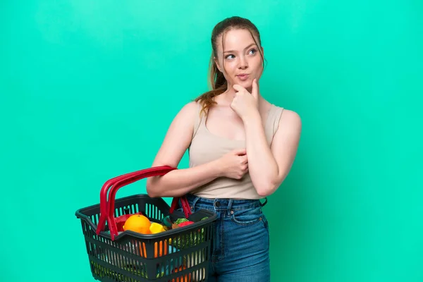 Jovem Segurando Uma Cesta Cheia Comida Isolada Fundo Verde Com — Fotografia de Stock