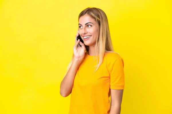 Blonde Uruguayan Girl Isolated Yellow Background Keeping Conversation Mobile Phone — Stock Photo, Image