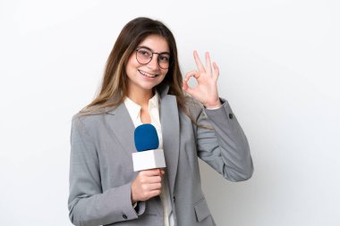 Beyaz arka planda izole edilmiş beyaz TV sunucusu genç kadın parmaklarıyla işaret veriyor.