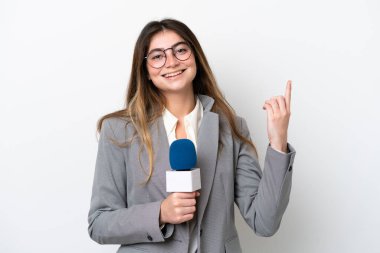 Young caucasian TV presenter woman isolated on white background showing and lifting a finger in sign of the best