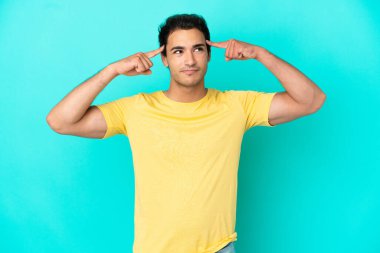 Izole mavi arka plan üzerinde şüpheleri ve düşünme beyaz yakışıklı adam