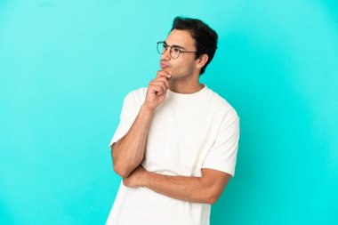 Caucasian handsome man over isolated blue background and looking up