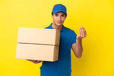 Teslimatçı, izole edilmiş sarı duvarın üzerinden para hareketi yapıyor.