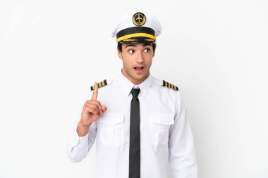 İzole edilmiş beyaz arka plan üzerinde uçan uçak pilotu bir fikir düşünüyor.