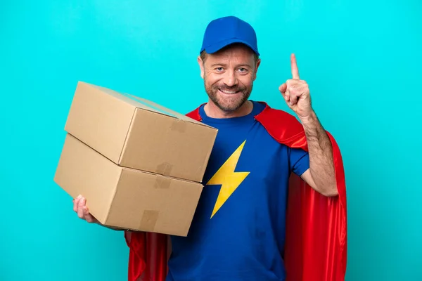 Super Hero Dostawy Człowiek Odizolowany Niebieskim Tle Wskazując Świetny Pomysł — Zdjęcie stockowe