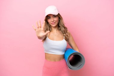 Genç sporcu kadın yoga derslerine giderken elinde beş parmaklı bir minder tutuyordu.