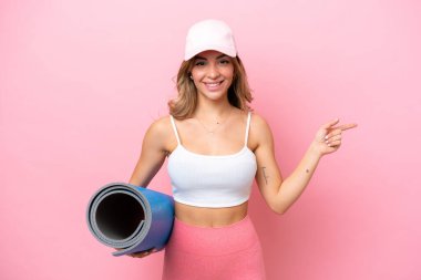 Genç sporcu kadın yoga derslerine giderken bir yandan da minder tutuyor.