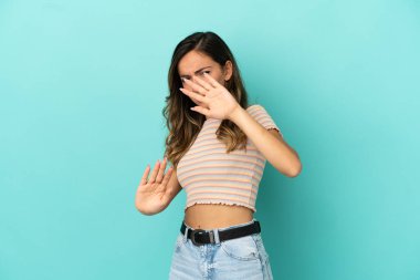 Genç kadın üzerinde izole mavi arka plan gergin Eller önden