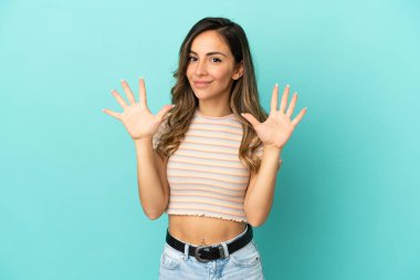 İzole mavi arka planda genç kadın parmak ile on sayma