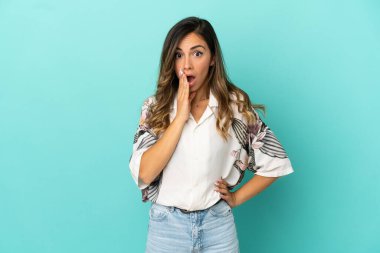 İzole mavi arka plan üzerinde genç kadın sürpriz ve doğru bakarken şok