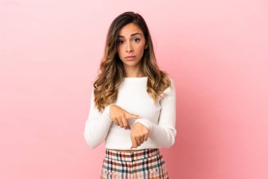 Tecrit edilmiş genç bir kadın geç kalma jesti yapıyor.