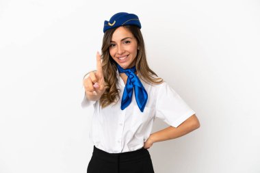 İzole edilmiş beyaz arka planda uçak hostesi parmağını kaldırıyor ve gösteriyor.