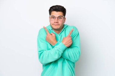 Beyaz fırında izole edilmiş beyaz, yakışıklı beyaz bir adam yan taraftaki kuşkuları işaret ediyor.