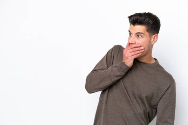 Beyaz fırında soyutlanmış yakışıklı beyaz bir adam yan tarafa bakarken sürpriz jest yapıyor.