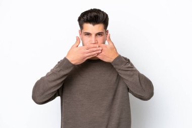 Beyaz fırında izole edilmiş yakışıklı beyaz bir adam ağzı elleriyle kapatıyor.