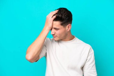 Genç, yakışıklı, beyaz bir adam mavi fırında baş ağrısı ile izole edilmiş.