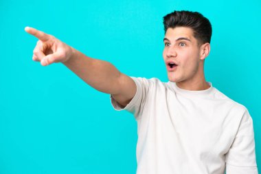 Genç, yakışıklı, beyaz bir adam mavi bir fırında izole edilmiş.